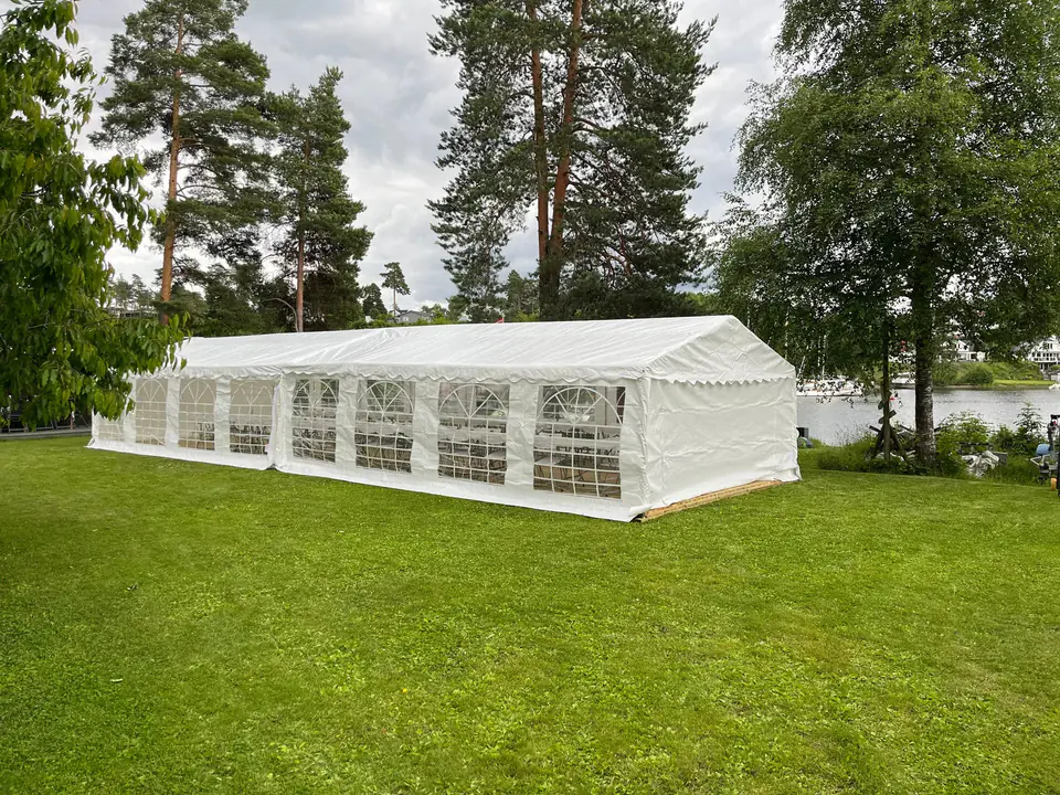 Partytelt på 5 × 16 m på en plen ved vannet, satt opp til bryllup på Nesøya