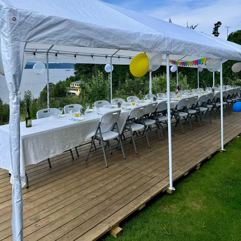 Tregulv under et partytelt med dekket langbord